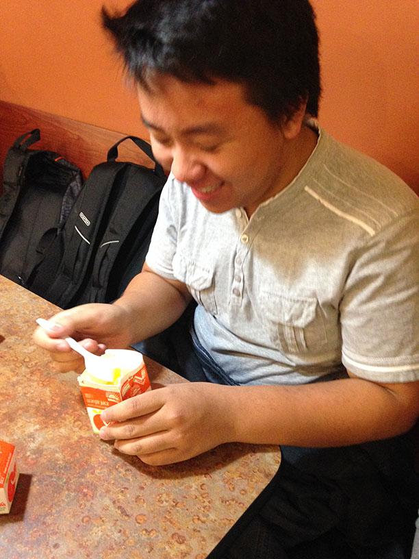 Senior Jaycob Yang eats his frozen orange juice with a spoon.