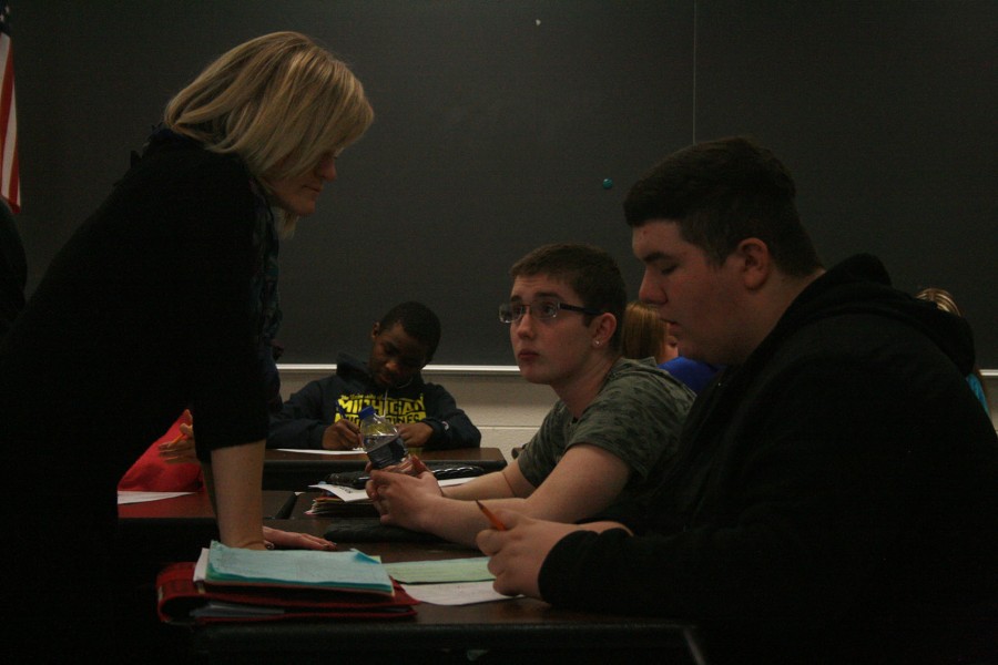 Mrs. Feikema helps Jared Taylor and Dakota Herbin with their worksheet.