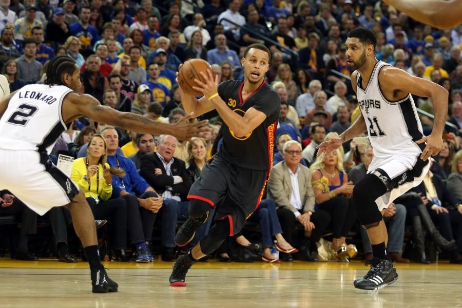 Golden States Stephen Curry drives past San Antonios Tim Duncan. (Ray Chavez/Bay News Area Group/TNS).