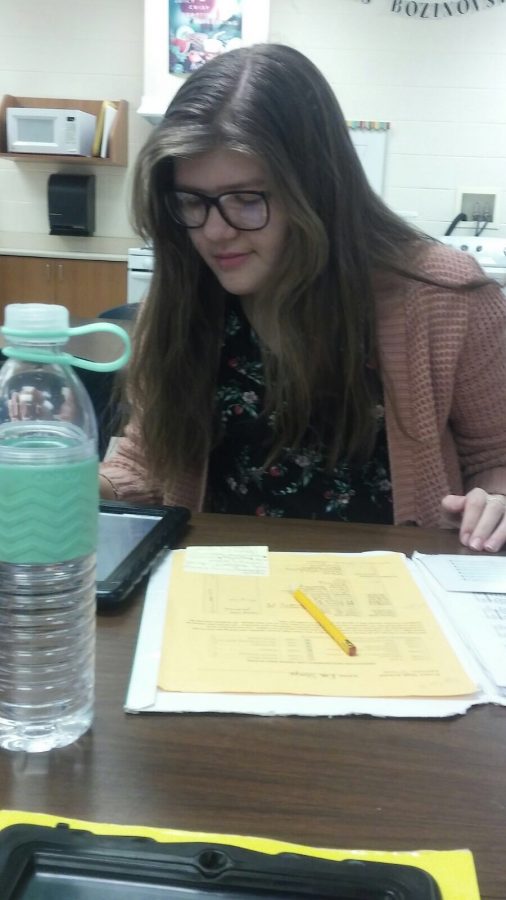 In this photo, junior Eva Steepe works on homework while wearing attire for Business Professional Day