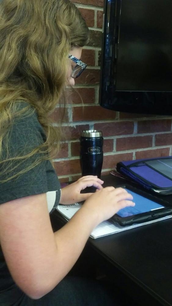The student pictured here is Rachel Gieleghem. She works on some homework while listening to music. She enjoys playing the clarinet in the band. 