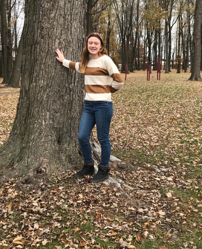 Ashlyn Baker is leaning against a tree at Licht Park. She loves going to the park and exploring nature. 