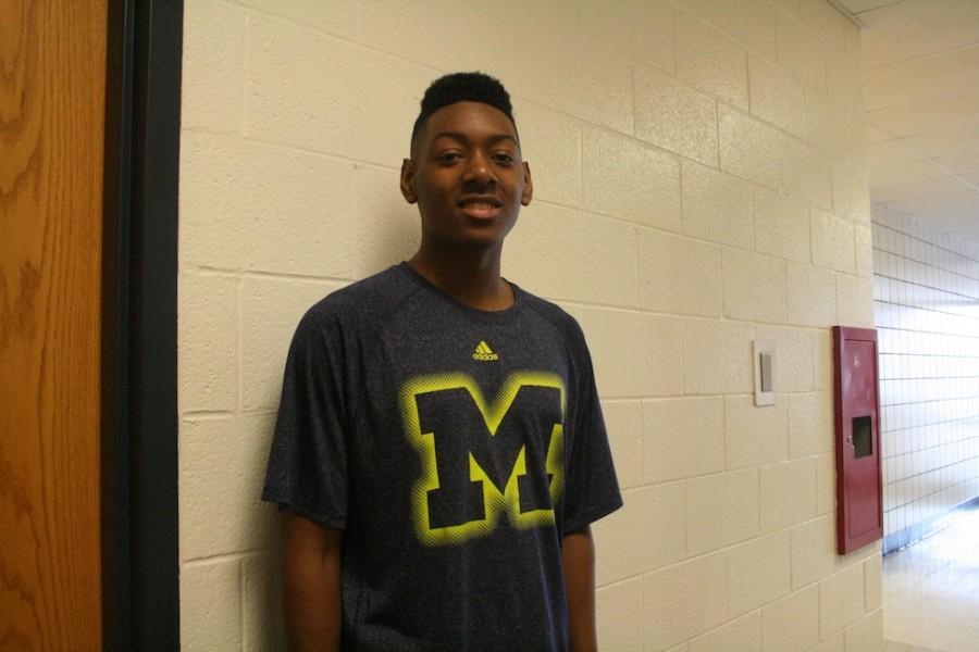Student proudly showing off his University of Michigan shirt to all of his classmates.