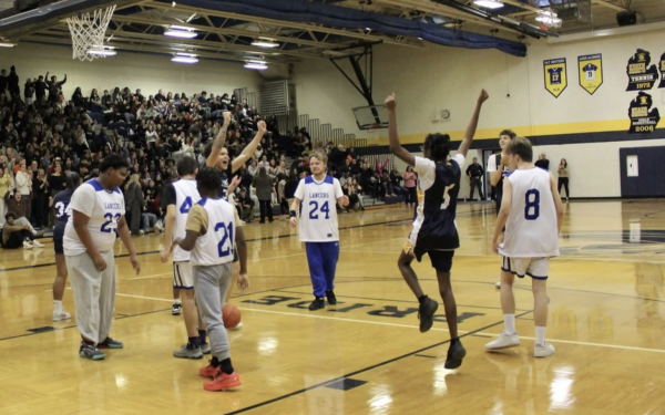 Players Taj Ammons and Chris Childs celebrating together after Ammons scored at the Unified basketball game vs. L'Anse Creuse.
